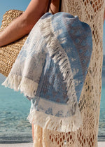 Dreamy luxury sand-free beach Turkish towel by Bezzazan, in straw beach bag held by model with white boho swimsuit cover