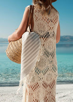 Harmonious Bezzazan lightweight Turkish beach towels for luxury minimalist lifestyle, in straw bag held by beach model in hat
