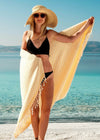 Harmonious thin Turkish Towel with stripes and tassels Bezzazan, held by girl in straw hat and modern black bikini on beach