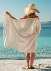 Bezzazan Harmonious lightweight Turkish towel with stripes and tassels handloomed by artisans, on a beach model in straw hat
