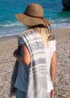 Flourishing XL by Bezzazan minimalist luxury Turkish Towel with stylish palm design, on boho girl in a hat at beach