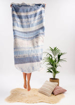 Dreamy throw blanket by Bezzazan, handloomed by turkish artisans, with fringe, styled in boho look studio with jumping model
