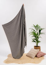 Aligned Bezzazan modern minimalist Throw Blanket, artisan handloomed tassels, boho look throw pillows, fur rug, and plant