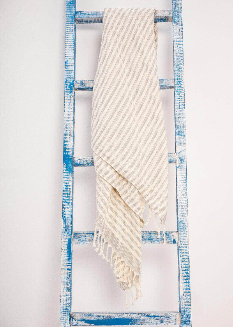 Harmonious minimalist Turkish towels with stripes and tassels by Bezzazan, styled as decorative throw on ladder for boho look