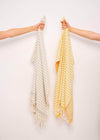 Harmonious Bezzazan minimalist Turkish towels with stripes and tassels handloomed by artisans, held against white background 